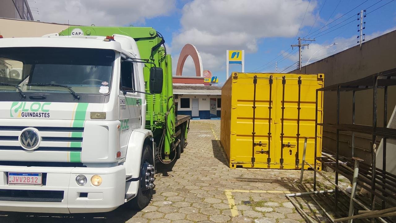 Caminhão munck do Grupo LOC Guindastes ao lado de container amarelo em Ananindeua, Pará